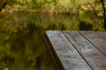 Fototapeta premium Part of wood table near the river, green background