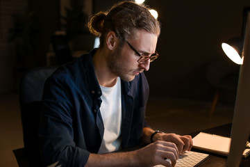 Man trying to meet deadline in office late in evening