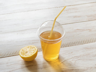 Iced tea in a clear plastic cup with a straw. Kombucha is a drink produced by fermenting tea with symbiotic culture of bacteria.