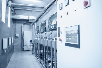 Automatic washing machine conveyor with blue plastic bottles inside in water manufacturing factory