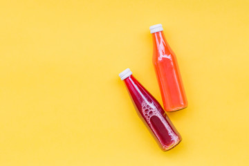 Juice Bottle Mock-Up, two gradient juice bottles on yellow background. Variety of colorful Smoothies, top view. Healthy Food concept