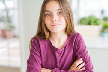 Beautiful young girl kid Relaxed with serious expression on face. Simple and natural with crossed arms