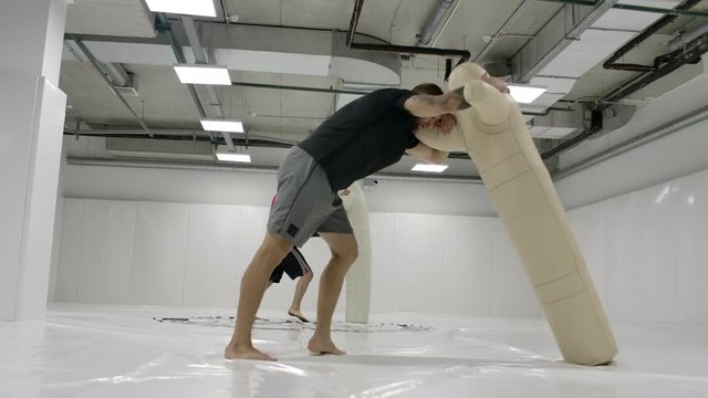 Two Male wrestlers perform a dummy throw on mats in slow motion. Professional grappling fighters.