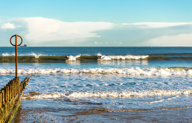 Two surfers on boards at Aberdeen city beach, Scotland
