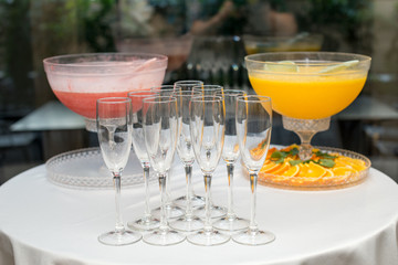 A pyramid of glasses. Orange and pink Champagne with fruits.