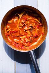 fish soup on an metallic pan, top view, natural direct light with shadow