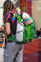 Unrecognizable tourist with a backpack standing near the showcase of shop souvenirs, travel and tourism concept