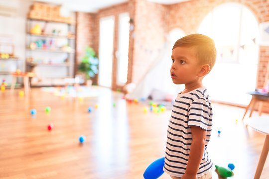 Beautiful toddler boy playing bowling at kindergarten