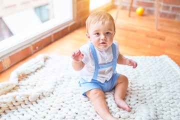 Beautiful toddler sitting on the blanket at kindergarten