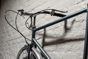 Detail of a bicycle at white brick wall