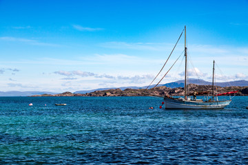 Naklejka premium A Small Sailboat in the Harbor of the Isle of Iona, With Isle of Mull in the BackgroundScotland