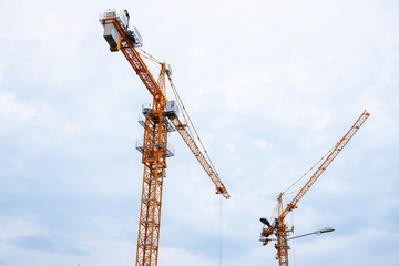 Fototapeta na wymiar Tower crane on sky background. Urban construction minimal landscape. Construction machine on duty