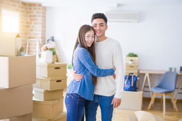 Beautiful young asian couple looking happy and smiling excited moving to a new home