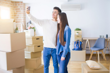Fototapeta na wymiar Young asian couple smiling taking a selfie photo with smartphone, moving to a new home together