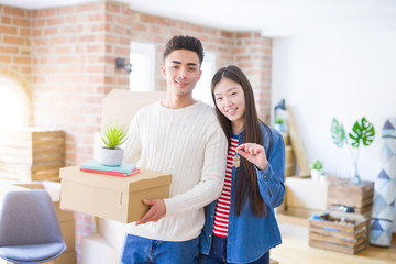 Fototapeta na wymiar Young asian couple holding keys of new house, smiling happy and excited moving to a new apartment