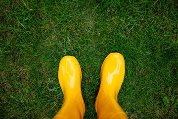 top view of yellow rubber boots on the grass