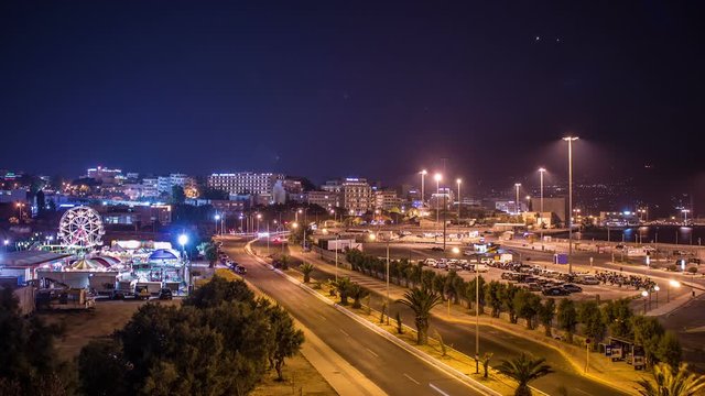 Time Lapse Traffic At Night On A Main Street City Heraclion, Greece Island, Crete, Silhouette Motion, Rear Lihgts Of Cars, Lantern Light On The Road, Light Trails On The Street,Ferris Wheel Time Lapse