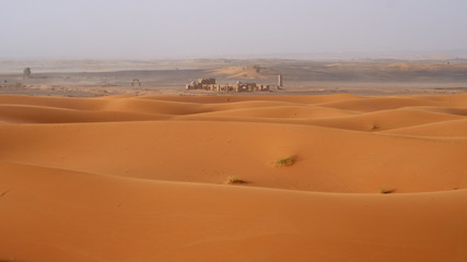 Fototapeta na wymiar Abandoned ruins in Sahara desert, landscape with a beautiful sand dunes in Morocco. 