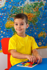 Kid playing with wooden colorful puzzle, education concept