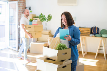 Fototapeta na wymiar Young couple moving to new apartment, beautiful woman moving cardboard boxes and smiling happy