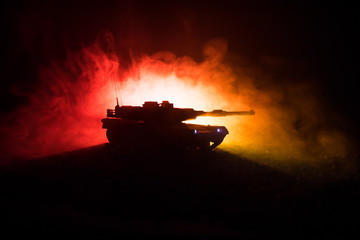 War Concept. Armored vehicle silhouette fighting scene on war foggy sky background at night....