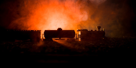 Train moving in fog. Ancient steam locomotive in night. Night train moving on railroad. orange fire background.