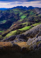 valle profundo de color verde con caserío y prados visto desde las alturas