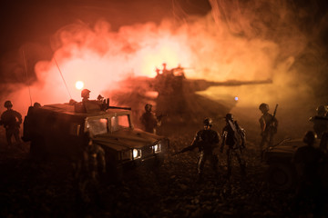 Fototapeta premium Military patrol car on sunset background. Army war concept. Silhouette of armored vehicle with soldiers ready to attack. Artwork decoration. Selective focus