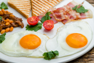 English Breakfast on a plate on wooden table