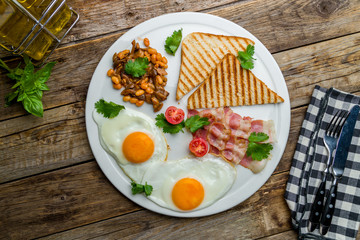 English Breakfast on a plate on wooden table