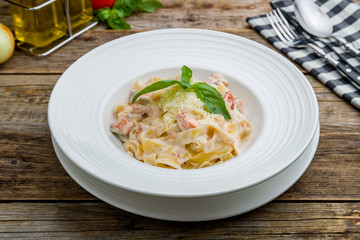 fettuccine with salmon on wooden table