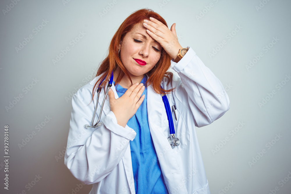 Wall mural Young redhead doctor woman using stethoscope over white isolated background Touching forehead for illness and fever, flu and cold, virus sick