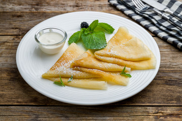 pancakes with sour cream on a white plate