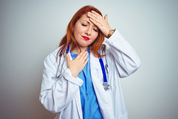 Young redhead doctor woman using stethoscope over white isolated background Touching forehead for illness and fever, flu and cold, virus sick