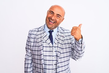 Middle age businessman wearing suit standing over isolated white background doing happy thumbs up gesture with hand. Approving expression looking at the camera showing success.