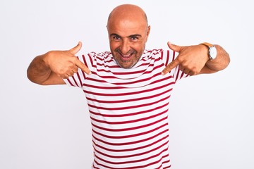 Middle age handsome man wearing striped t-shirt standing over isolated white background looking...