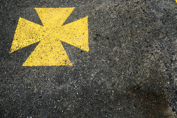 Yellow maltese cross, ambulance parking lot marked with yellow symbol.