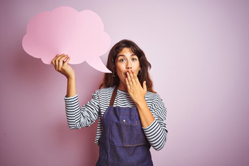 Beautiful chef woman wearing apron holding cloud speech bubble over isolated pink background cover mouth with hand shocked with shame for mistake, expression of fear, scared in silence, secret concept