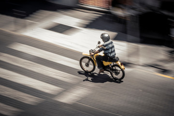 Obraz na płótnie Canvas Anonymous man riding motorbike on street