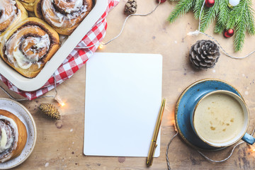 Cinnamon rolls and cup of coffee on festive background.