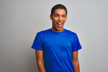 Young handsome arab man wearing blue t-shirt standing over isolated white background winking looking at the camera with sexy expression, cheerful and happy face.