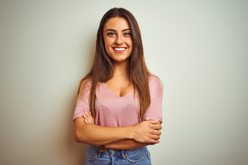 Fototapeta premium Young beautiful woman wearing casual t-shirt standing over isolated white background happy face smiling with crossed arms looking at the camera. Positive person.