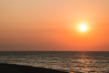 Fototapeta na wymiar Sunrise on the beach, orange-red gradient in the sky. Copy space.