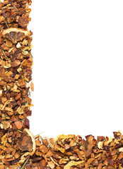 Heap of dried fruit tea infusion with oranges and strawberries mixed with tea leaves and assorted herbs frame border texture flat lay top view from above over white