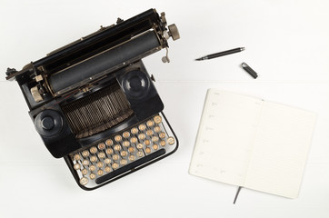 Vintage retro typewriter and open notebook with pen on white wooden table background top view flat lay from above - journalism or writer concept