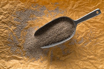 Whole, organic white chia seeds heap in metal scoop on brown packing paper background flat lay top...