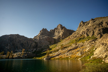 Mountains around peaceful alpine lake at sunset