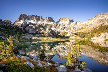 Reflections in Ediza Lake in California Eastern Sierras at sunrise with snow on jagged peaks