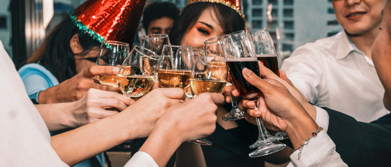 group of diversity business people having fun and having wine glass toasting together in corporate new year and Christmas party with music and dancing at workplace