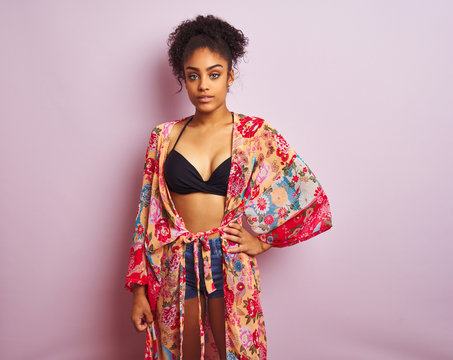 Young beautiful african american woman on vacation standing wearing bikini and colorful caftan